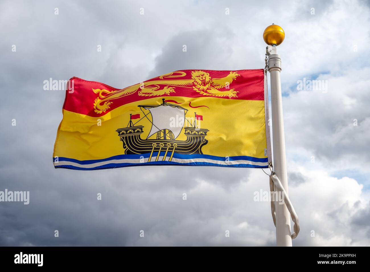 Die Flagge von New Brunswick verzichtet an einem bewölkten kanadischen Tag. Stockfoto