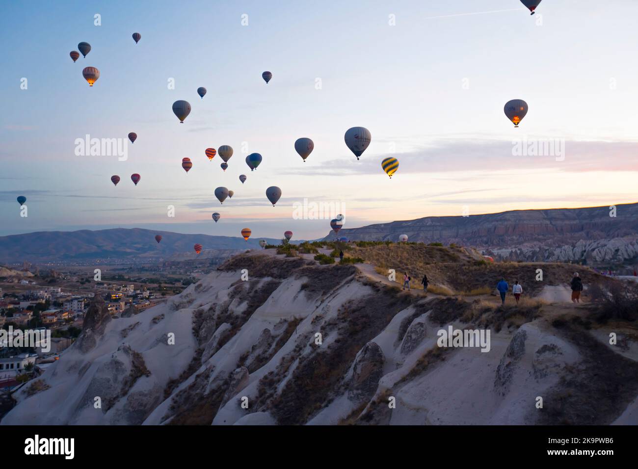 Atemberaubender Sonnenuntergang aus der Vogelperspektive mit zahlreichen farbenfrohen Heißluftballons, die über Kappadokien fliegen. Türkische Touristenattraktionen. Hochwertige Fotos Stockfoto
