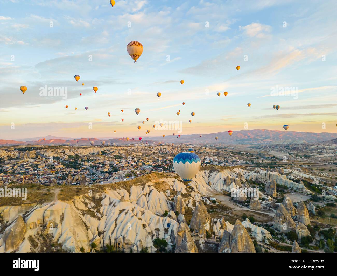 Atemberaubende Drohnenansicht von Hunderten von Heißluftballons, die während des Sonnenaufgangs über das ikonische Kappadokien der Türkei, die unterirdischen Städte und das Tal der Feenkamine und die Felsformationen fahren. Hochwertige Fotos Stockfoto