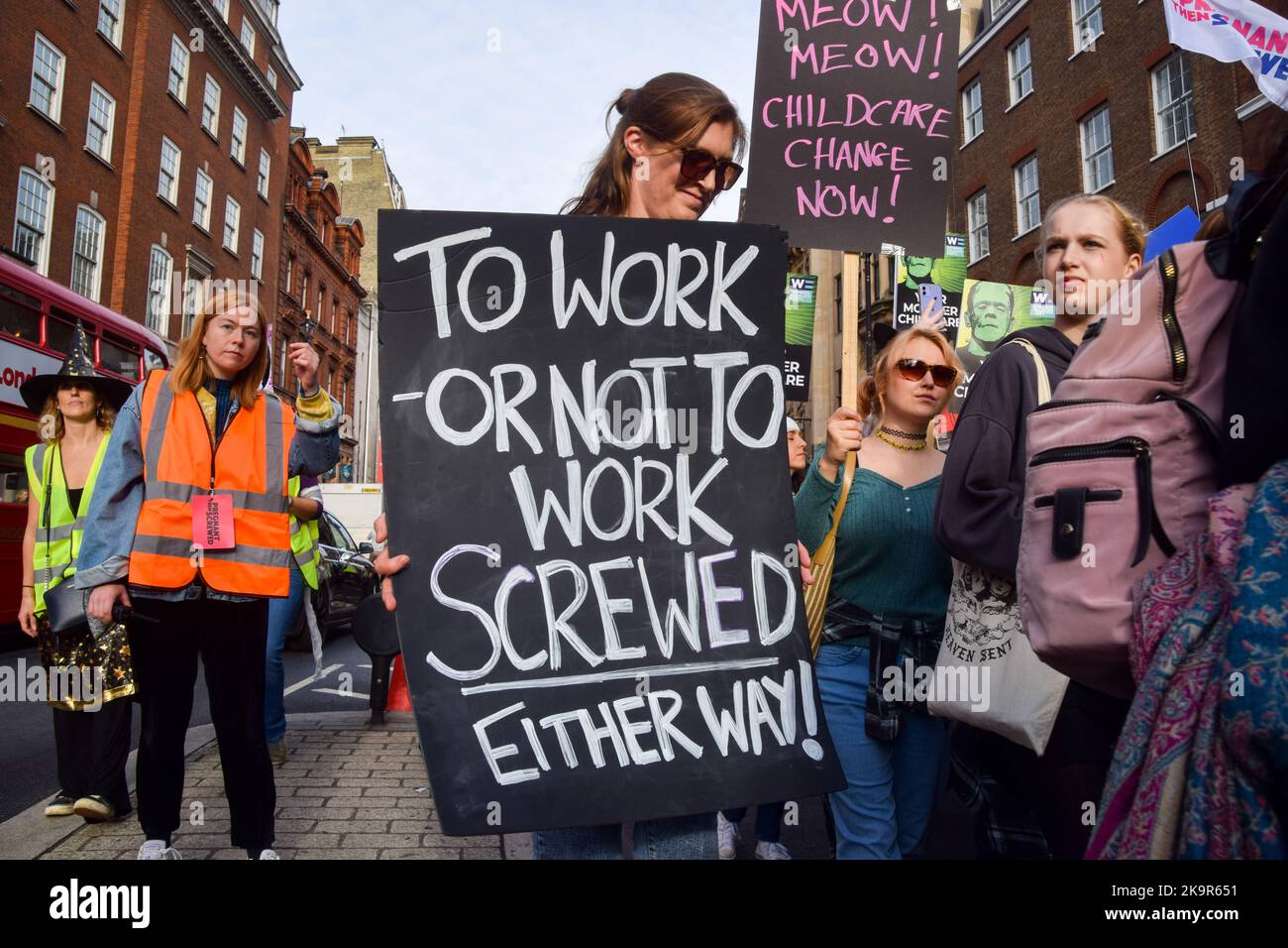 London, Großbritannien. 29. Oktober 2022. Ein Protestler hält während der Demonstration ein Plakat mit der Aufschrift „zu arbeiten oder nicht zu arbeiten, in beide Richtungen geschraubt“ in Whitehall. Eltern und Kinder, viele in Kostümen, marschierten vom Trafalgar Square zum Parliament Square und forderten erschwingliche Kinderbetreuung, flexibles Arbeiten und ordnungsgemäß bezahlten Elternurlaub während des Halloween-Motto „March of the Mumien“. Kredit: SOPA Images Limited/Alamy Live Nachrichten Stockfoto