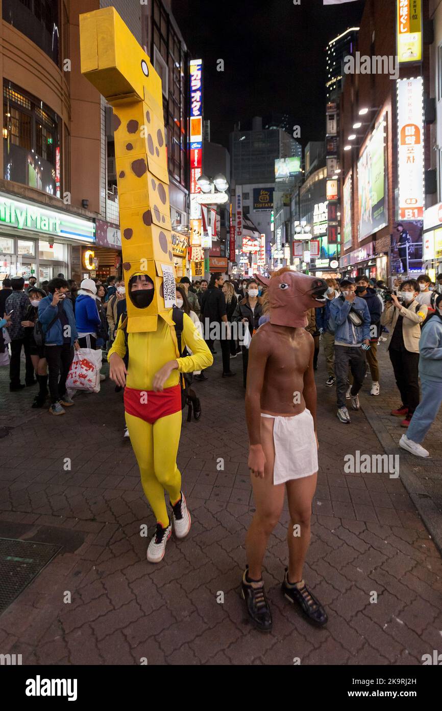 Tokio, Japan. 29. Oktober 2022. Männer sahen auf der Straße eine Giraffe und ein Pferdekostüm tragen, während die Menschen Halloween im Shibuya Center Gai genießen. Nach einigen Jahren des Coronavirus und der Einschränkung des antisozialen Verhaltens scheinen die berühmten Shibuya Halloween Feiern etwas von ihrer Energie zurückzugewinnen, obwohl eine starke Polizei- und Sicherheitspräsenz und Alkoholverbote auf der Straße verwendet werden, um die Exzesse früherer Ereignisse einzudämmen. (Foto von Damon Coulter/SOPA Images/Sipa USA) Quelle: SIPA USA/Alamy Live News Stockfoto