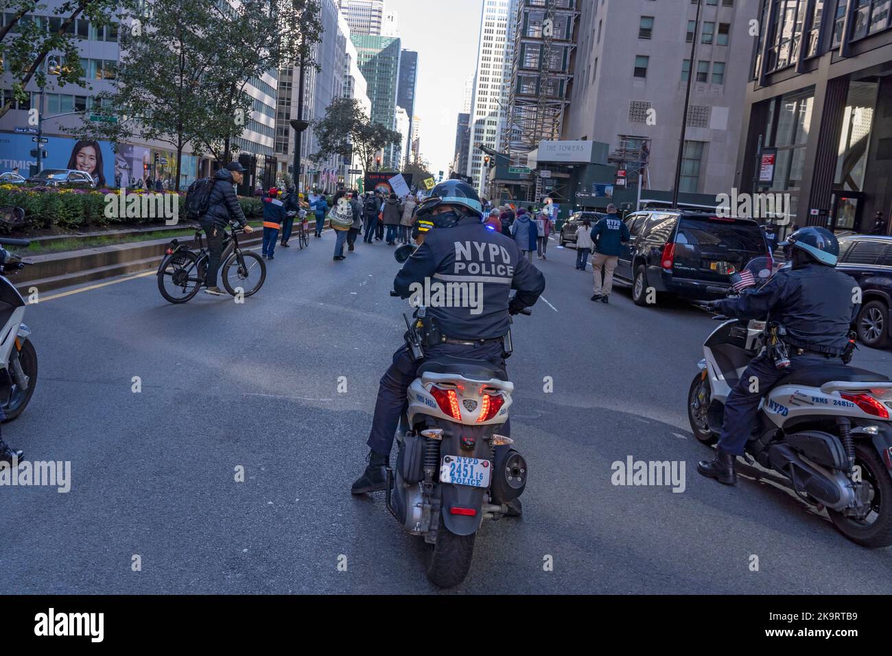 New York, USA. 29. Oktober 2022. NYPD-Polizeibeamte auf Motorroller folgen Klimaaktivisten, die auf der Park Avenue marschieren und den Verkehr von den NYC-Büros von JPMorgan nach BlackRock blockieren, während einer „Occupy Park Avenue“-Demonstration am 29. Oktober 2022 in New York City. Dutzende Klimaaktivisten mit einem großen Banner mit der Aufschrift „Occupy Park Avenue“ und Plakaten, die die fossile Energiewirtschaft anvisierten, marschierten entlang der Park Ave vom neuen Hauptsitz der JPMorgan Bank zum Hauptsitz des Finanzinvestitionsunternehmens BlackRock, um gegen die Investitionen dieser Unternehmen in fossile Energieträger zu protestieren. Kredit: Ron Adar/Alamy Live Nachrichten Stockfoto