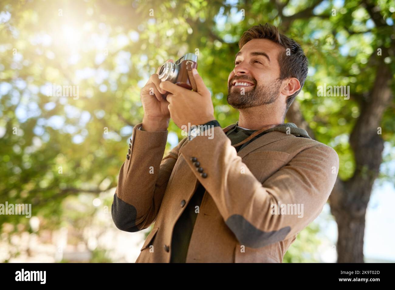 Hes ein Fotograf im Herzen. Ein hübscher junger Mann, der während seines morgendlichen Pendelzuges fotografiert. Stockfoto