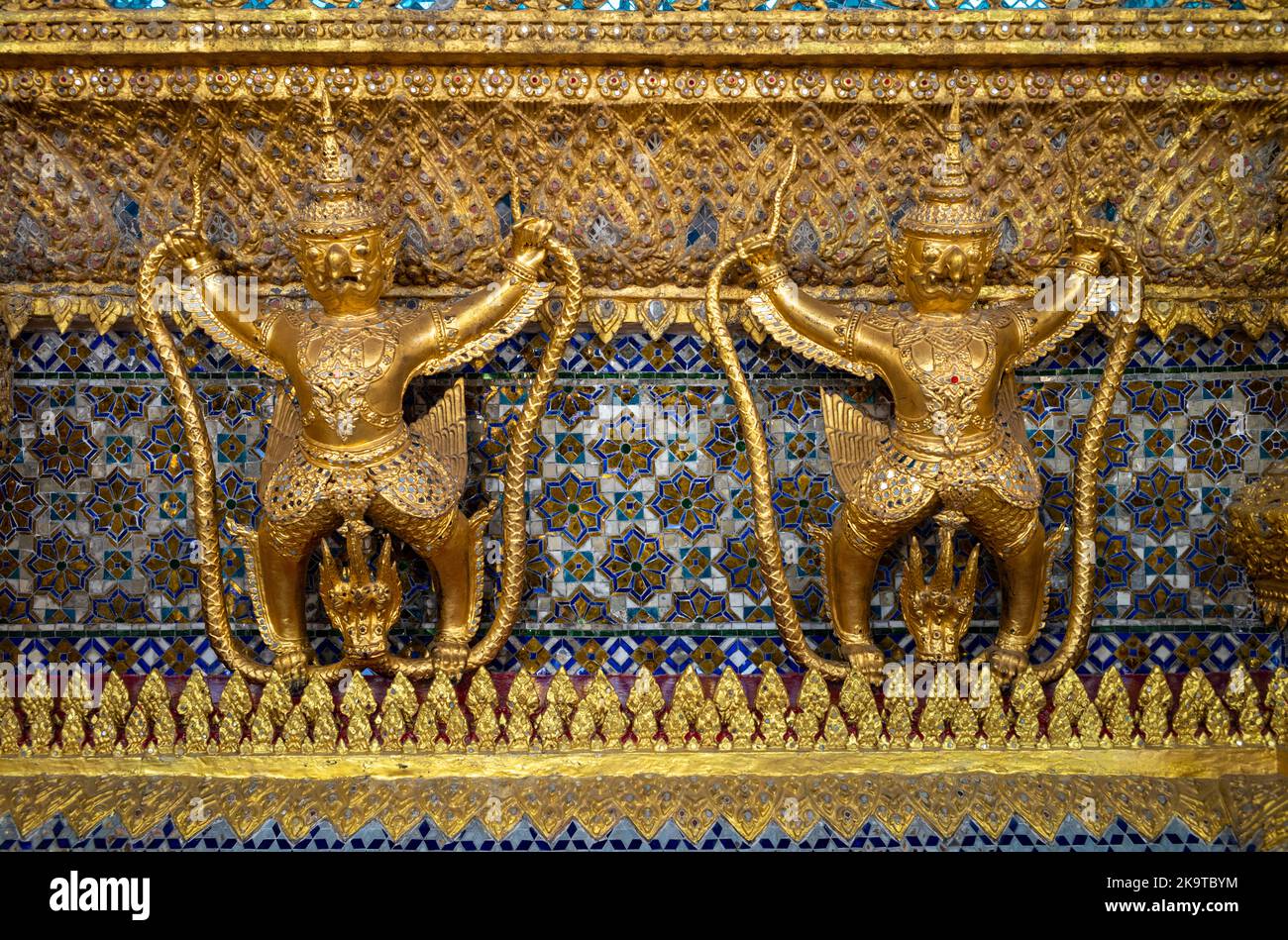 Alte buddhistische Statuen und Tempelwächter im Golden Stupa (Phra Si Ratana Chedi) neben dem Tempel des Smaragd-Buddha in Bangkok. Stockfoto