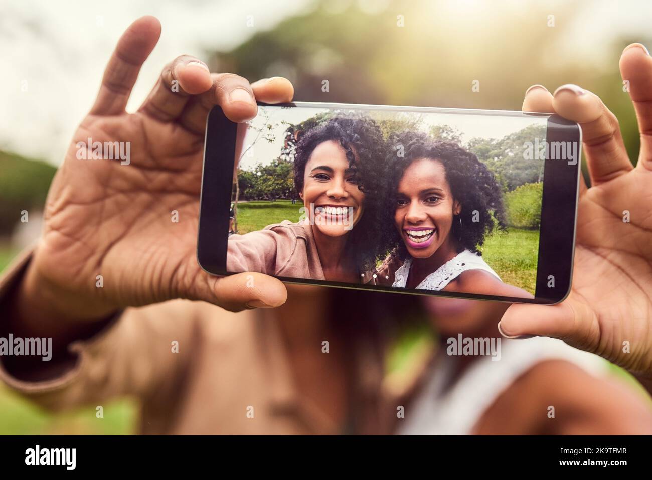 Sie sind Selfie-Königinnen. Zwei weibliche beste Freundinnen, die ein Foto in einem öffentlichen Park machen. Stockfoto