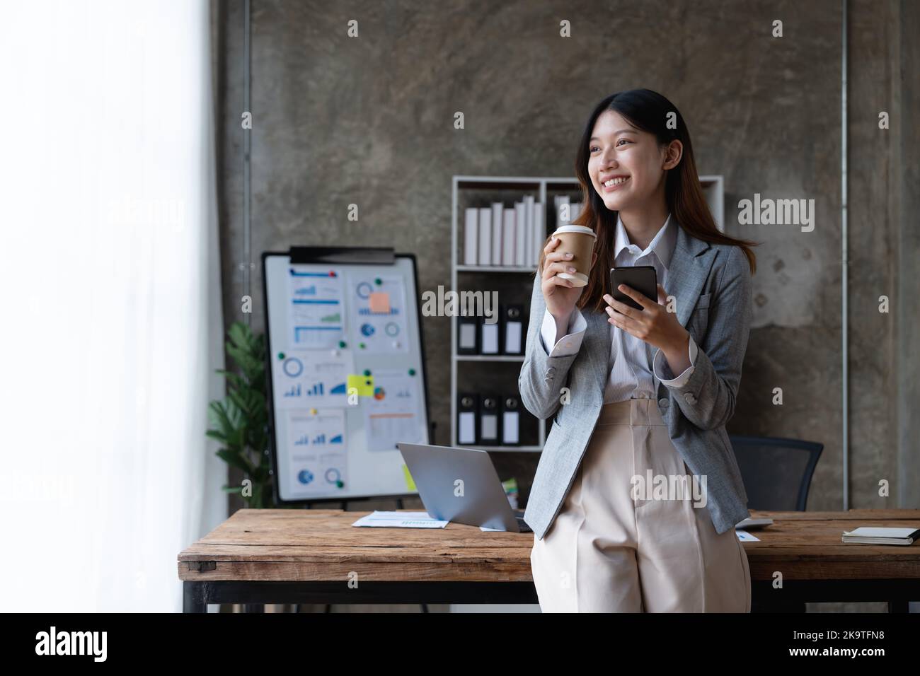 Portrait zuversichtlich asiatische Geschäftsfrau im Büro. Mit Handy. Stockfoto