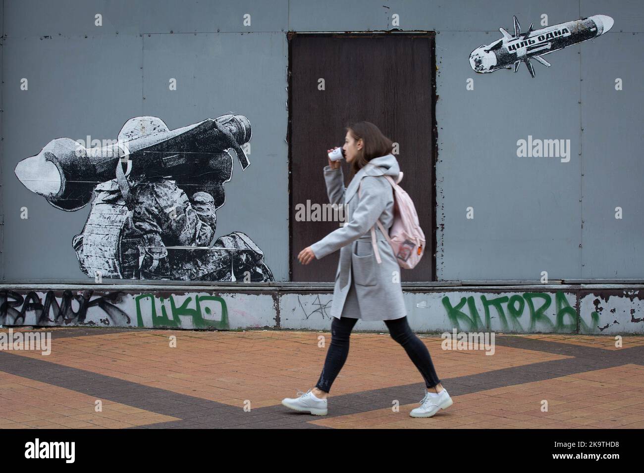Kiew, Ukraine. 29. Oktober 2022. Ein Mädchen kommt an Graffiti vorbei, auf dem ein ukrainischer Militärangehöriger mit einem tragbaren Javelin-Panzerabwehrraketensystem aus den USA im Zentrum von Kiew geschossen hat. Diese Raketen gehören zu den Waffen, die westliche Verbündete an ukrainische Streitkräfte schicken, um ihnen bei ihrem Kampf gegen die russischen Eindringlinge zu helfen. Speer wird weithin als Symbol der Verteidigung der Ukraine angesehen. Kredit: SOPA Images Limited/Alamy Live Nachrichten Stockfoto
