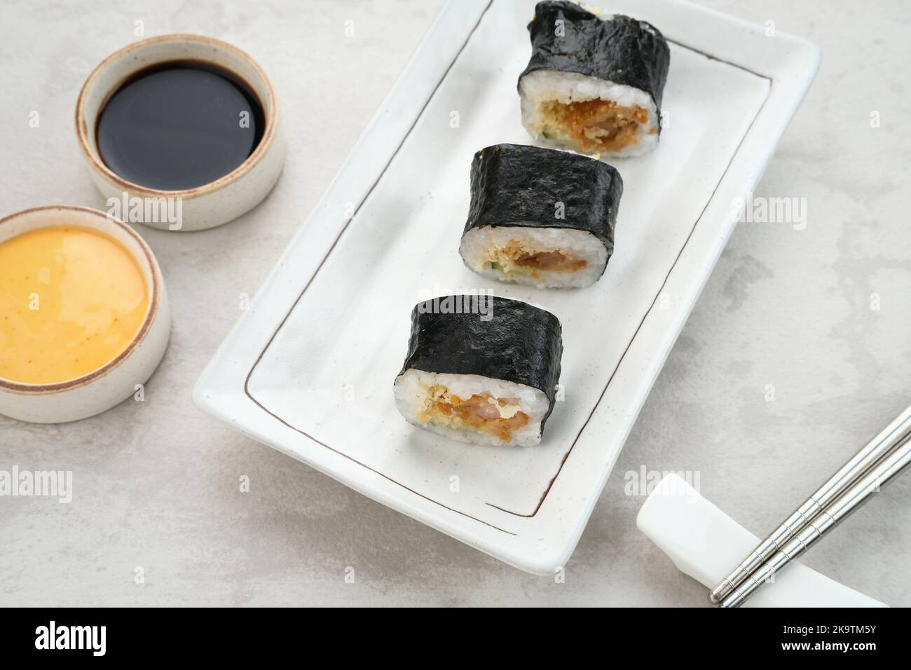 Sushi-Brötchen mit Nori auf weißem Teller. Stockfoto