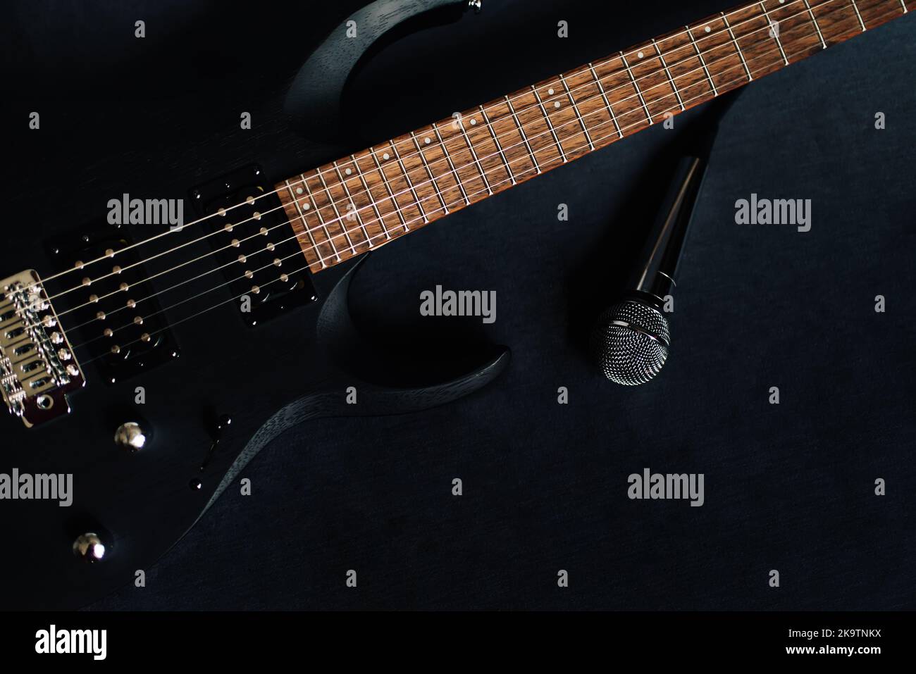 Nahaufnahme schwarze E-Gitarre auf schwarzem Hintergrund Stockfoto
