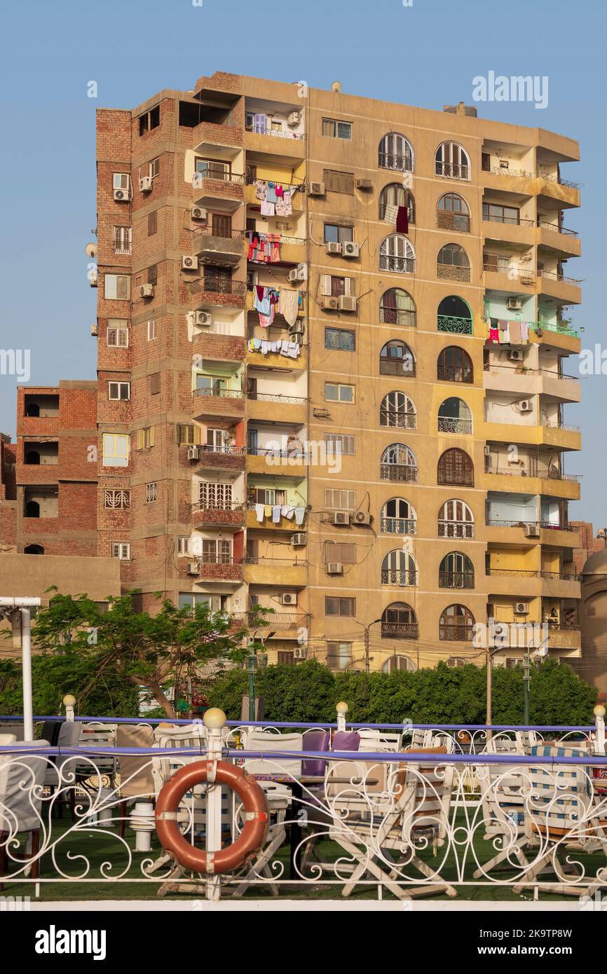 Wohngebäude am Ufer des Nils mit dem Oberdeck eines Kreuzfahrtschiffes im Vordergrund, Ägypten, Afrika Stockfoto