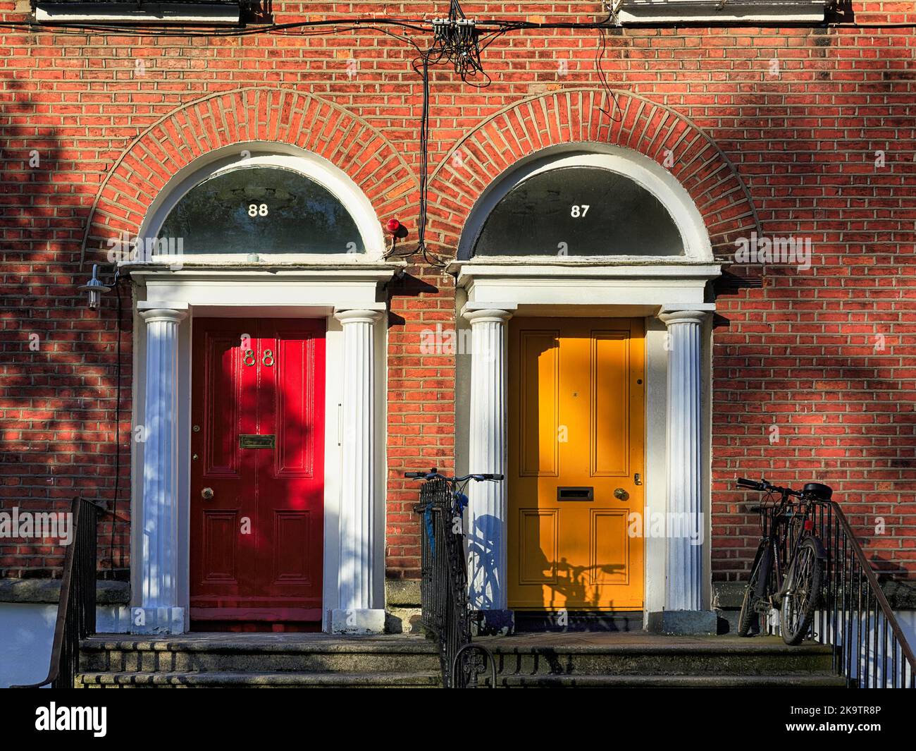 Typische Reihenhäuser mit bunten Türen, gelb und rot, Dublin, Irland Stockfoto