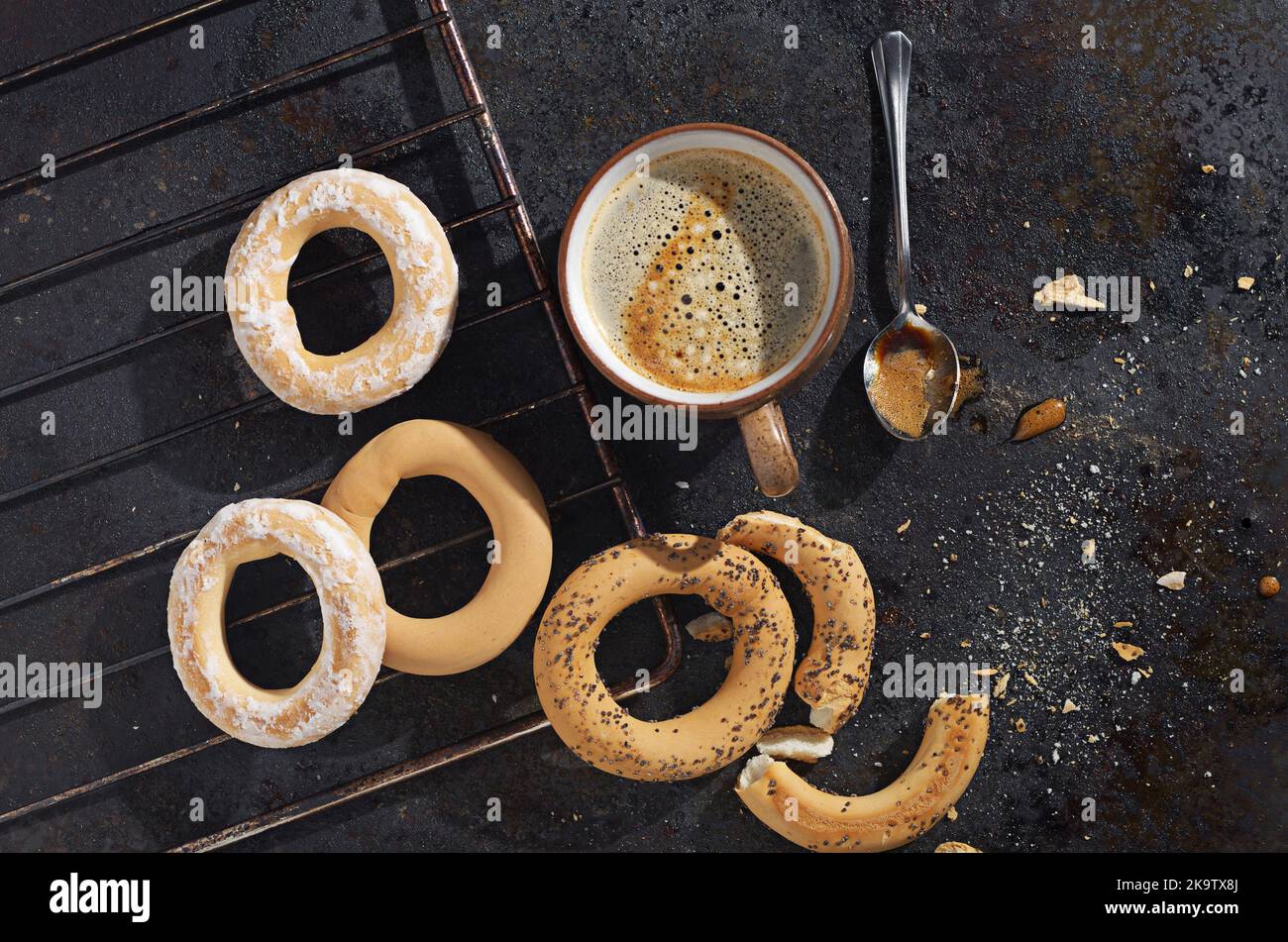 Frisch gebackene Bagels und eine Tasse Kaffee auf einem Backblech aus Metall, Draufsicht Stockfoto