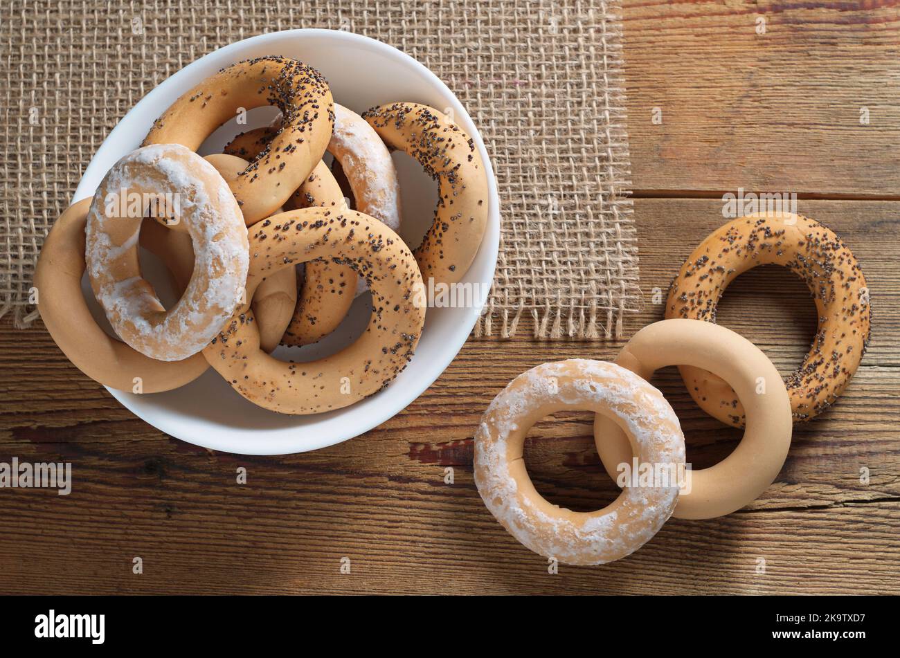 Blick aus der Höhe auf verschiedene hausgemachte Bagels in einer weißen Schüssel auf dem Tisch Stockfoto