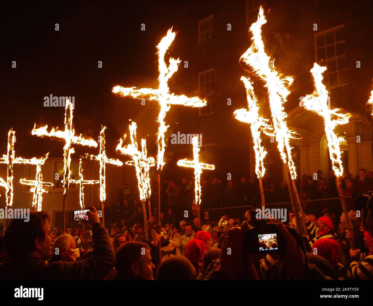 Zelebranten fangen die siebzehn Märtyrer-Kreuze ein, die am Lewes House vorbei in Richtung Howard House, Lewes Bonfire, 2014, gehen Stockfoto