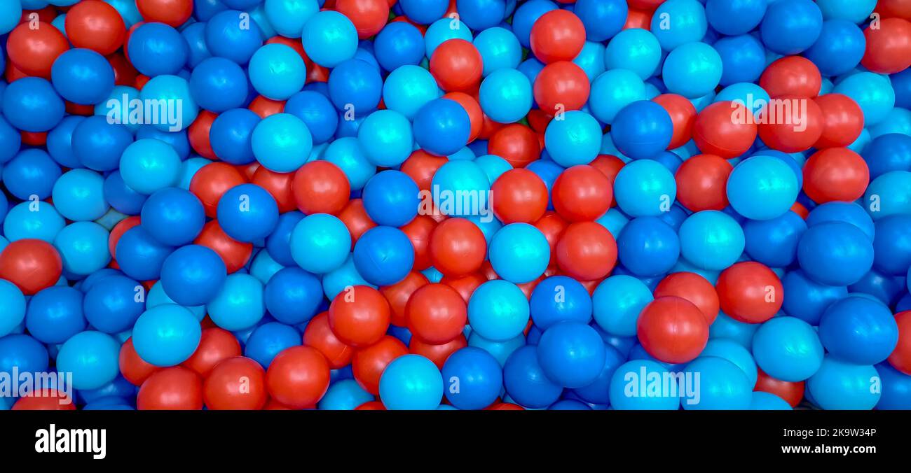 Viele blaue und rote Plastikbälle für kleine Kinder zum Spielen im Kinderzentrum. Stockfoto