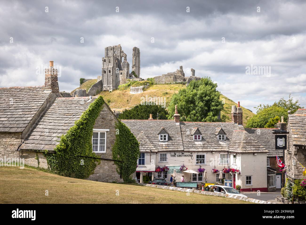 DORSET, Großbritannien - 06. Juli 2022. Historisches Dorf mit Burgruinen von Corfe im Hintergrund. Haupttouristenattraktion im Purbeck-Viertel von Dorset, Großbritannien Stockfoto