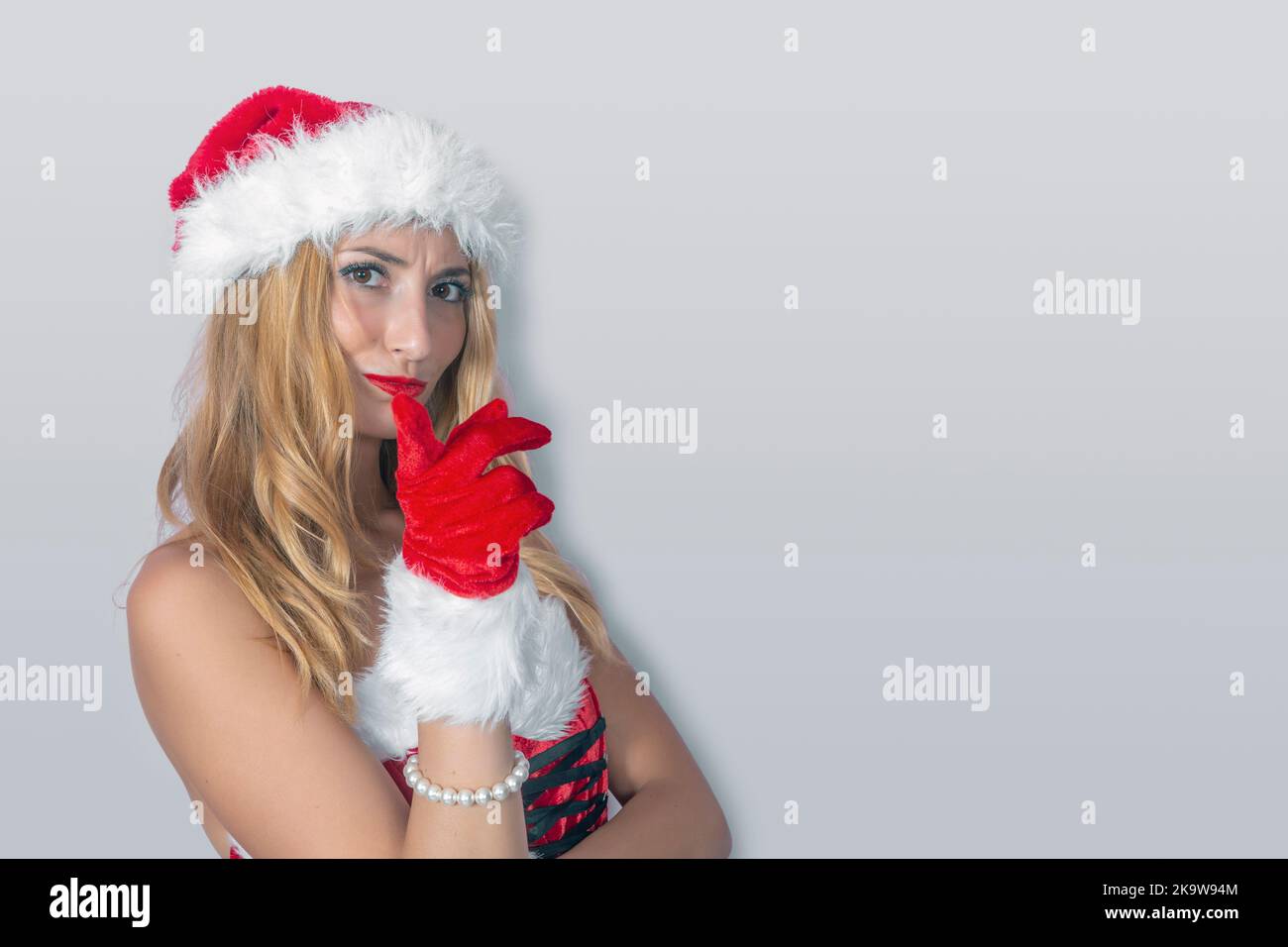 Nahaufnahme einer jungen blonden Frau im Weihnachtsmann-Kostüm, isoliert vom Hintergrund Stockfoto