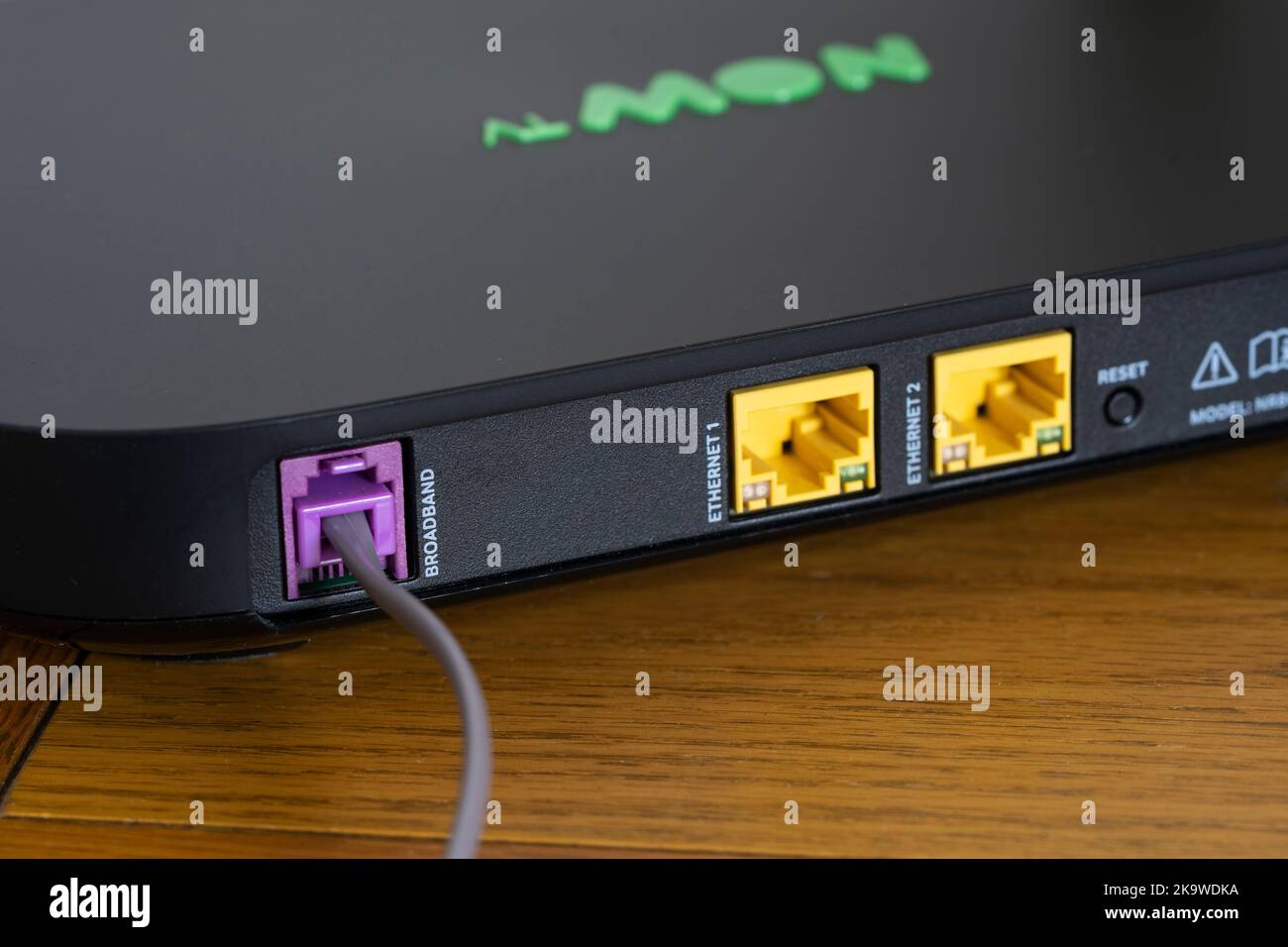 Makro-Nahaufnahme der Rückseite des drahtlosen Breitband-Internet-Routers mit einem Kabel, das an die Breitbandbuchse angeschlossen ist. Thema: Britische Breitbandanbieter Stockfoto