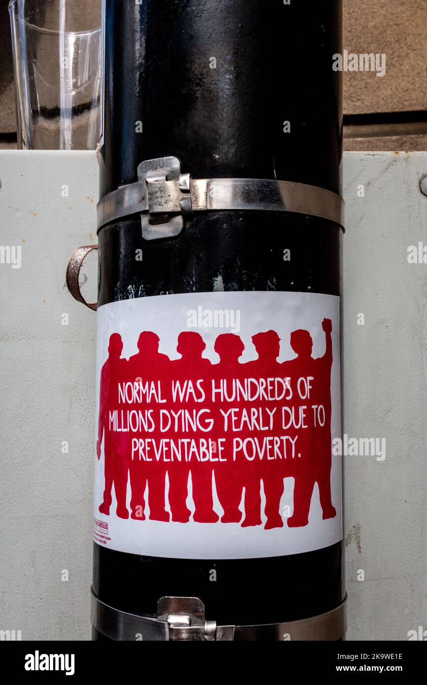 Normal waren Hunderte Millionen, die jährlich aufgrund vermeidbarer Armut sterben - ein Aufkleber auf einem Posting in Cambridge, Großbritannien Stockfoto