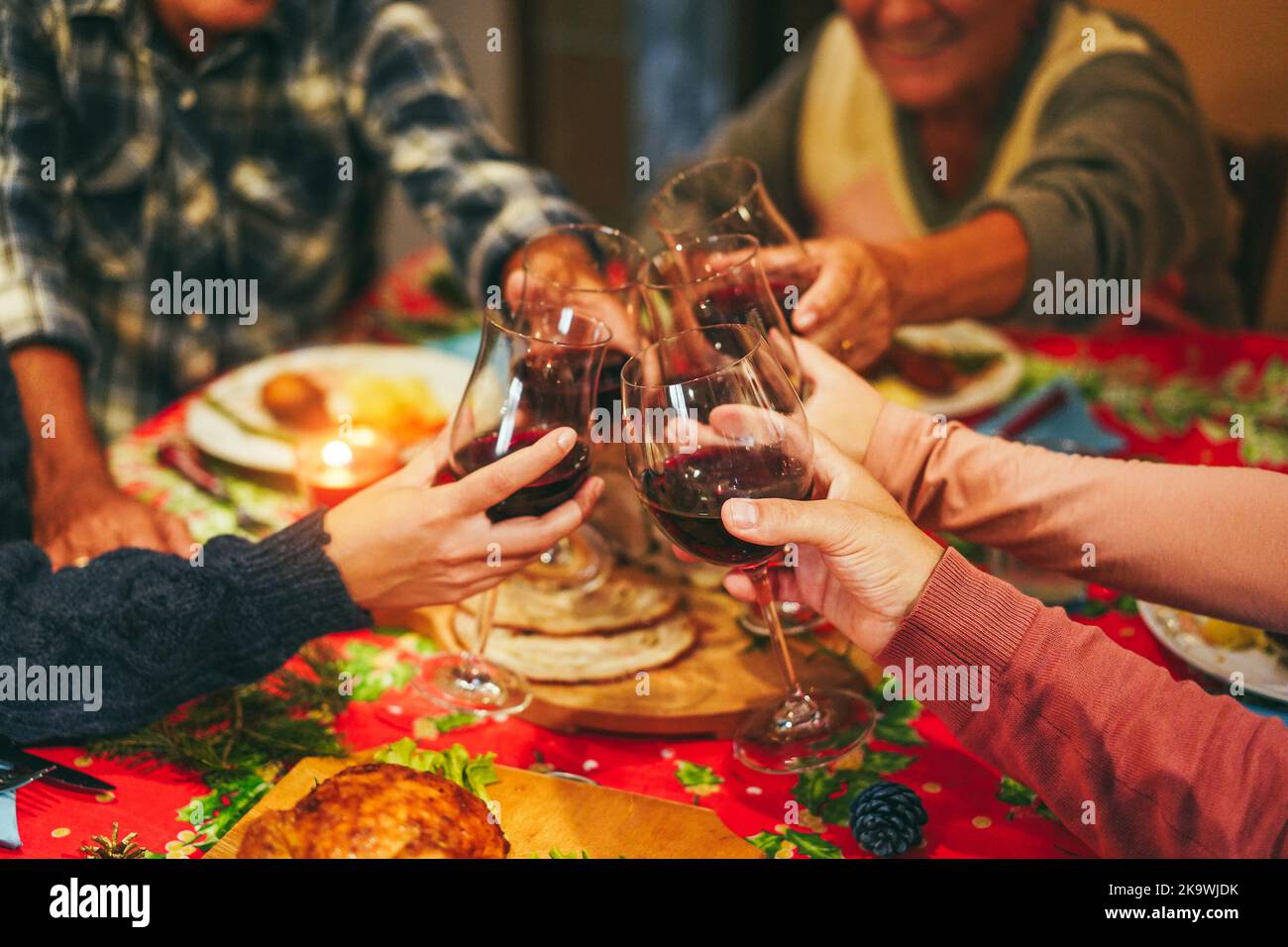 Fröhliche Familie jubelt mit Wein beim gemeinsamen Weihnachtsessen - konzentrieren Sie sich auf die rechte Hand Stockfoto
