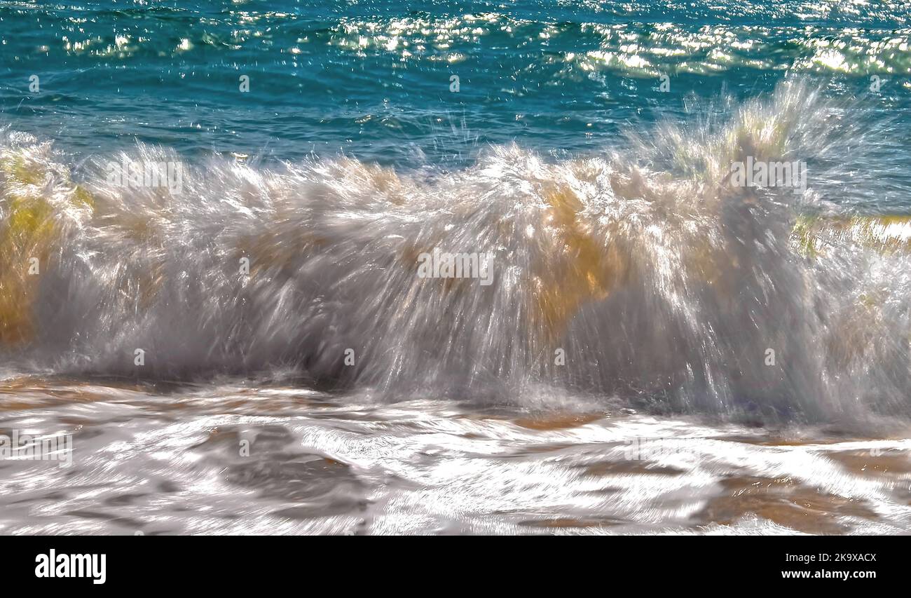 Surfen Sie vom Meer an einem Strand der Algarve in Zeitlupe Stockfoto