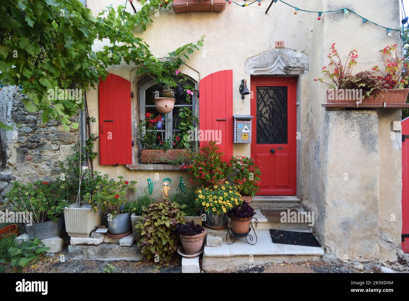 Attraktives Dorfhaus mit roten Fensterläden & Türen in der Altstadt oder im historischen Viertel von Dieulefit Drome Frankreich Stockfoto