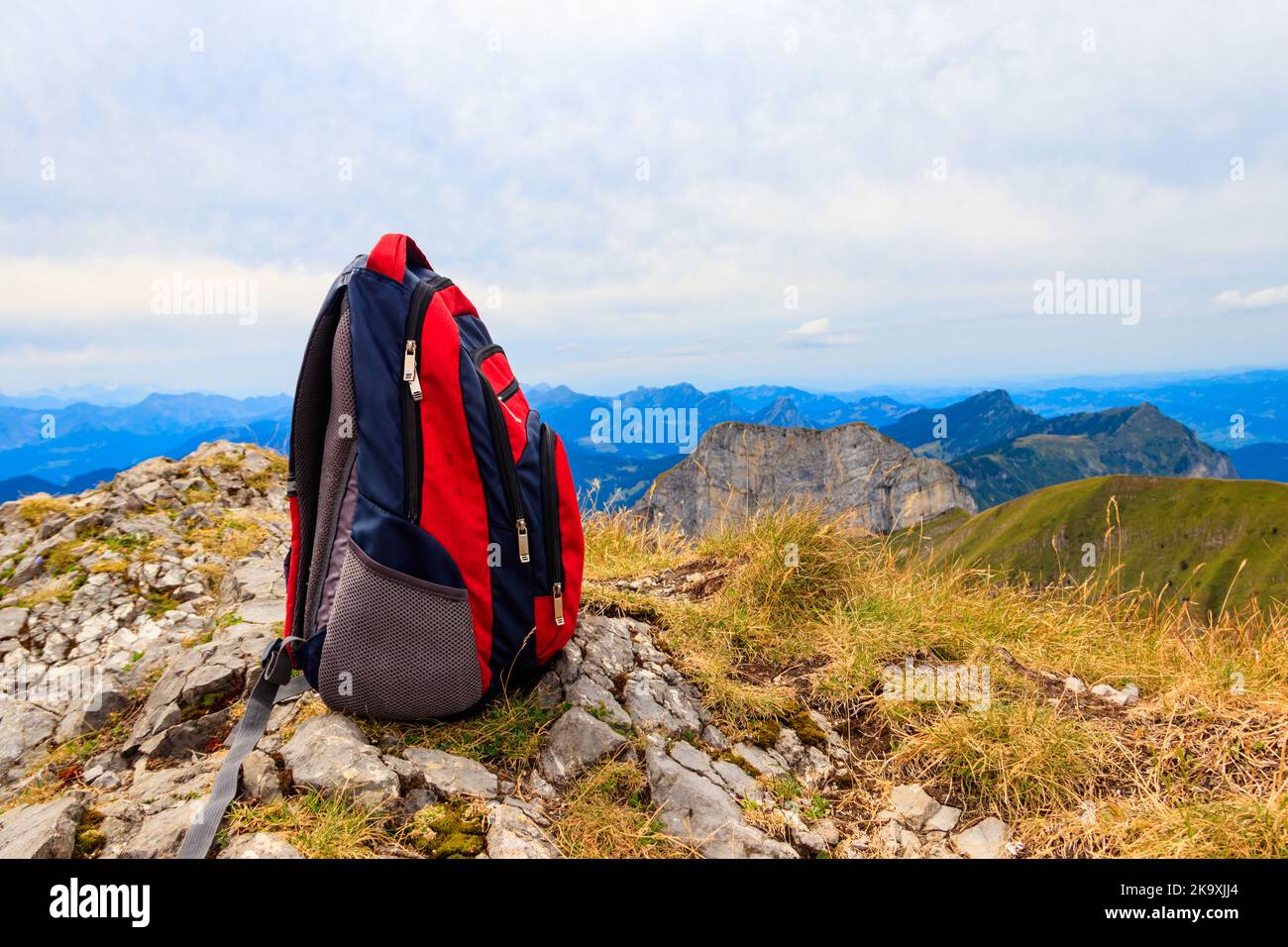 Touristischer Rucksack auf dem Hintergrund der Berge in den Schweizer Alpen. Reise im Freien Stockfoto