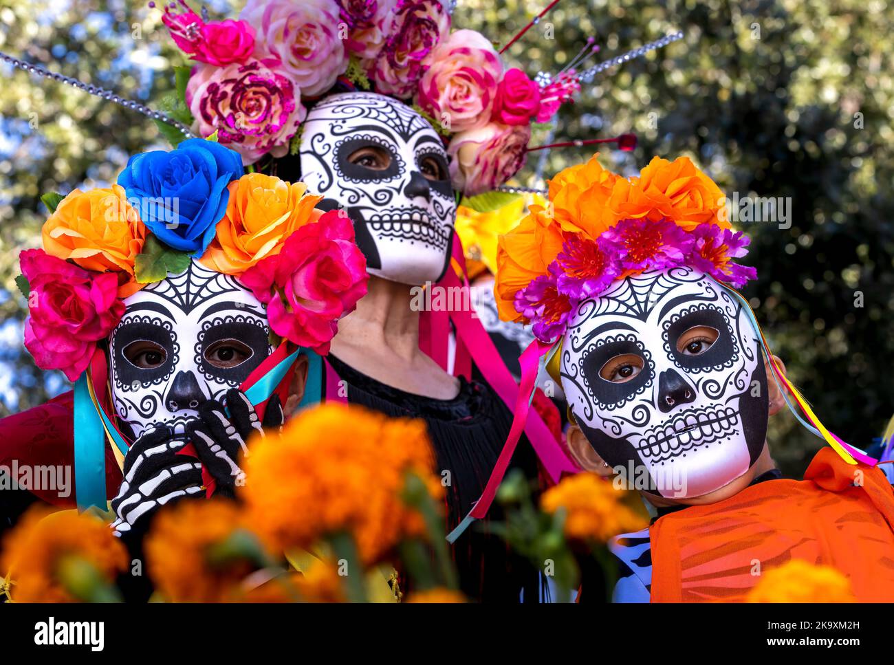 Vier Frauen mit traditionellen Dia de Los Muertos-Totenkopfmasken nehmen an der berühmten hispanischen Feier Teil. Die Menschen am Day of the Dead Festival Stockfoto