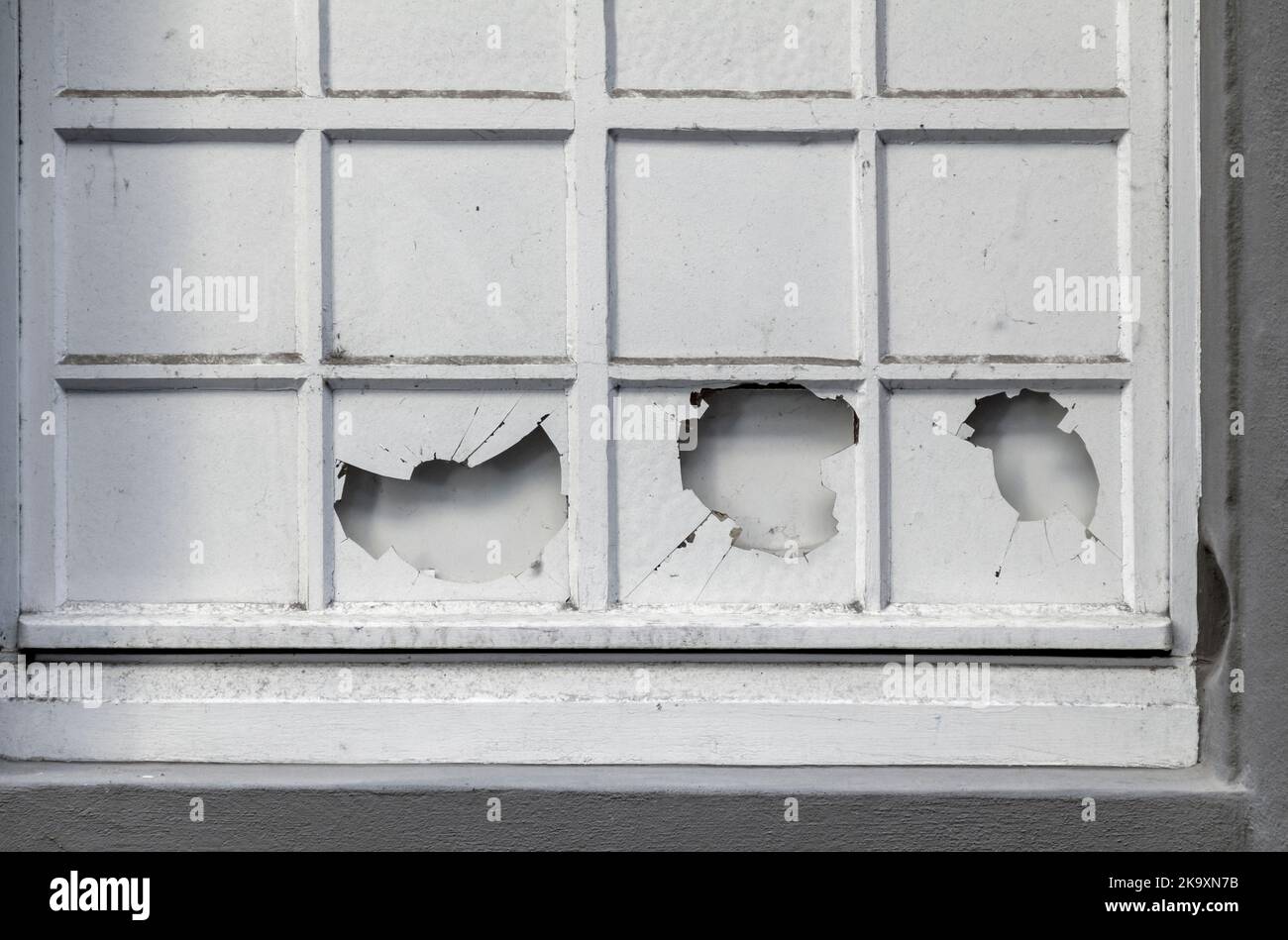 Detailaufnahme eines weiß gestrichenen Fensters mit einigen zerbrochenen Scheiben Stockfoto