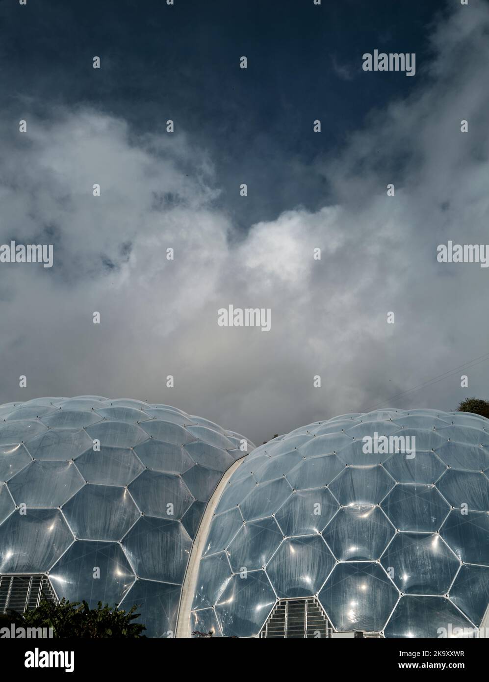 Honigwaben-förmige Öko-Biomes beim Eden Project in Bodelva, St. Austell, Cornwall vor einem blauen bewölkten Himmel. Stockfoto
