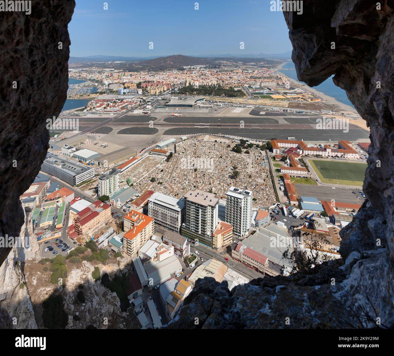 Blick von einer Schießschlange in den Großen Belagerungstunneln, Gibraltar, über den Flughafen von Gibraltar in die spanische Stadt A La Linea de la Concepcion. Im Stockfoto