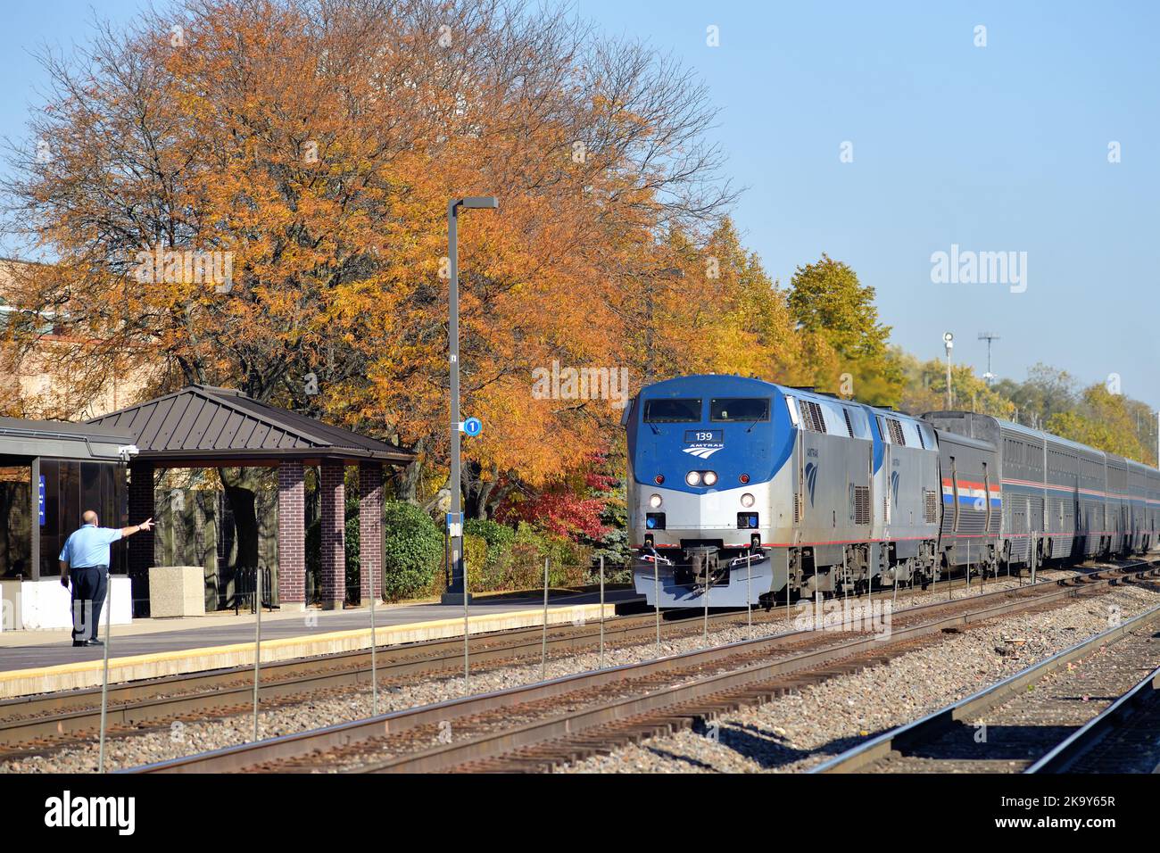 Naperville, Illinois, USA. Ein Amtrak-Mitarbeiter stickt den Ingenieur des ankommenden kalifornischen Zesthyr am IS an und kommt am lokalen Bahnhof an. Stockfoto