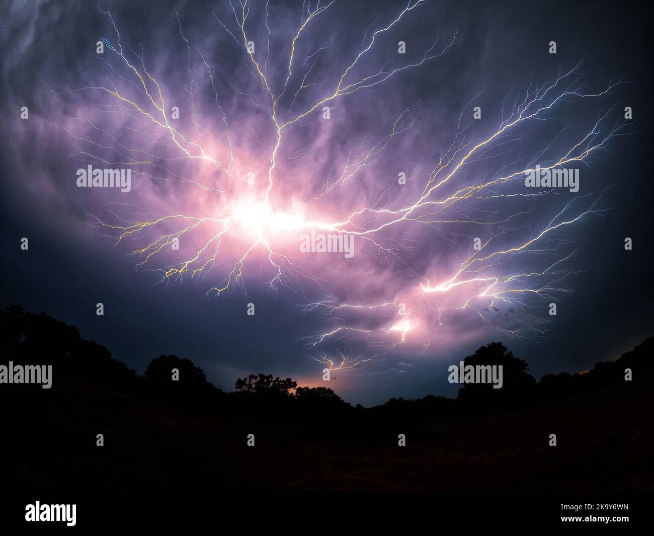 Mehrere Spinnenblitze, die bei einem Gewitter in der Nacht in einem Weitwinkel über den Himmel ragen Stockfoto