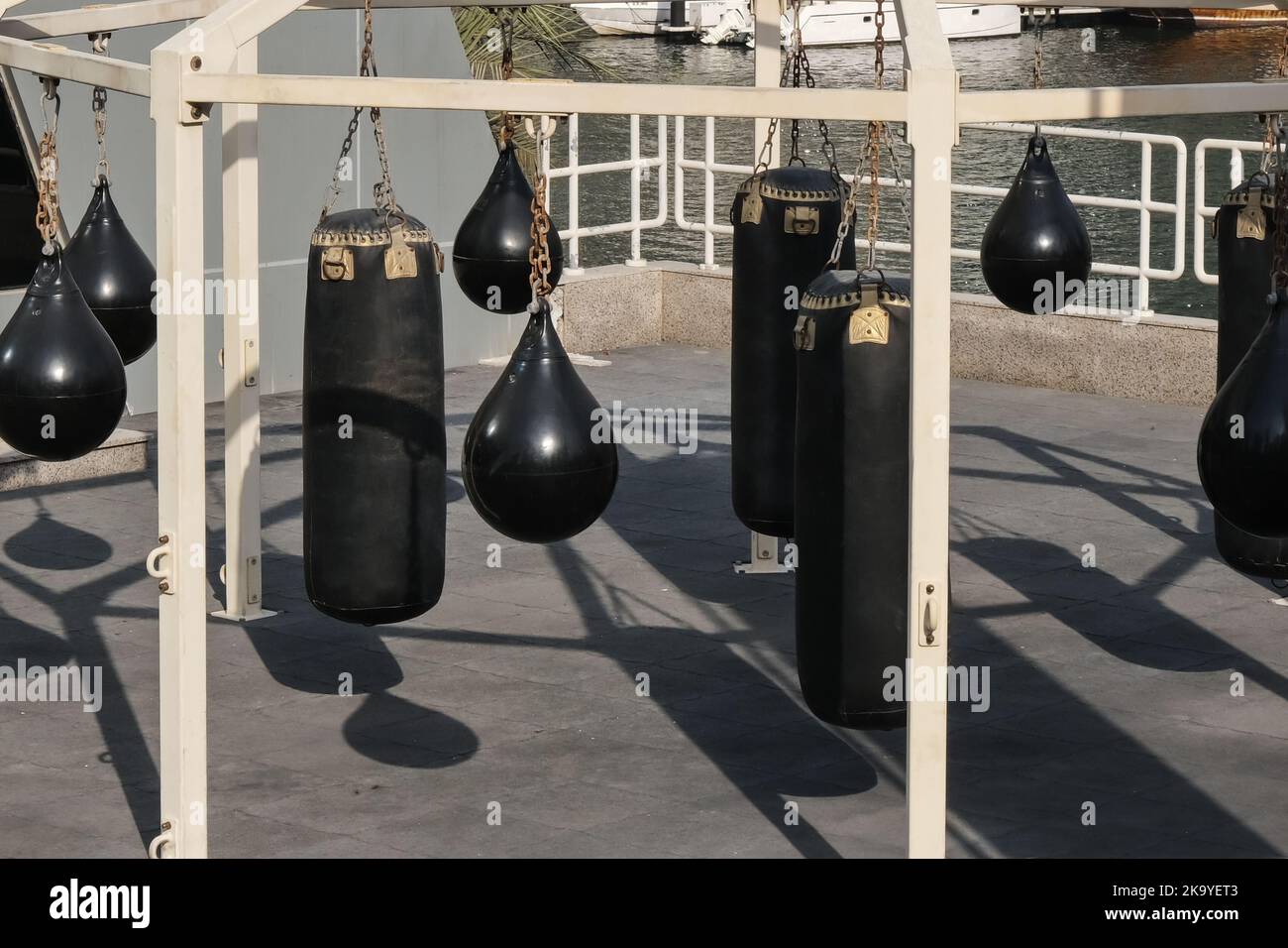 Set aus schwarzen Boxsäcken, Boxbirnen für Kickboxen und Fitnessübungen. Freiluft-Fitnessbereich der Stadt mit Boxsäcken Stockfoto