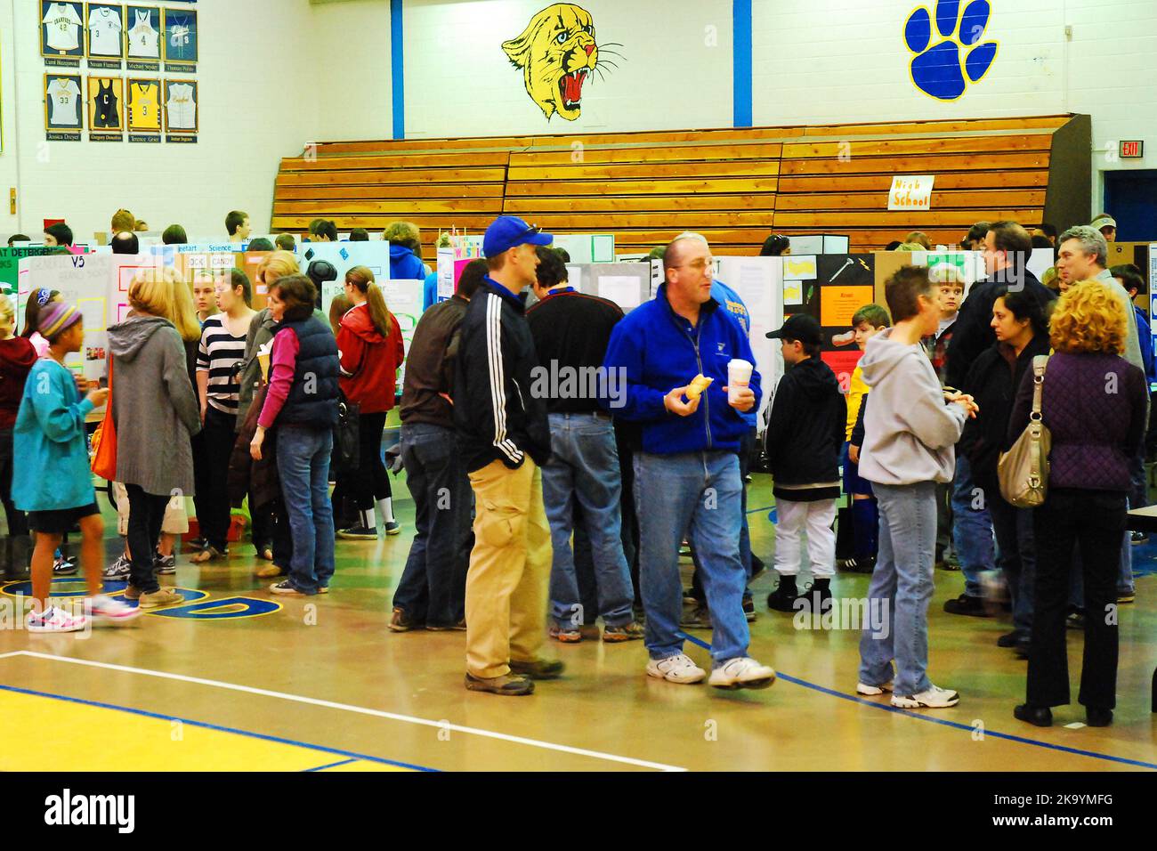 Prents, Lehrer und Schüler versammeln sich in einem Gymnasium, um sich die auf einer High School Science Fair präsentierten Displays anzusehen Stockfoto