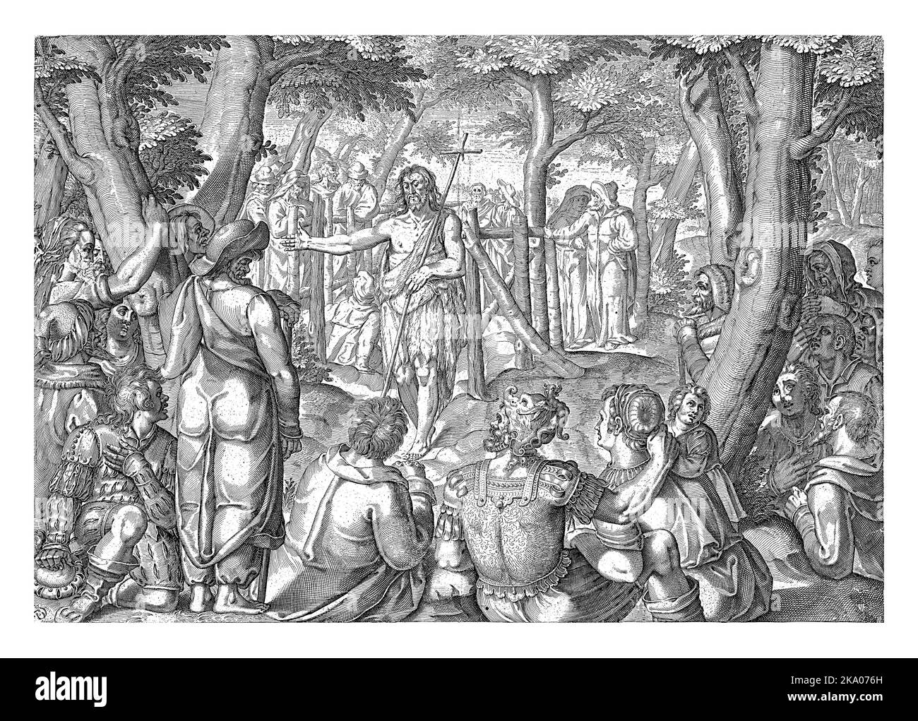 Johannes der Täufer steht inmitten einer Gruppe von Menschen vor einer Art Gartenzaun. Die Leute stehen und sitzen zwischen Bäumen und lauschen den Gästen Stockfoto