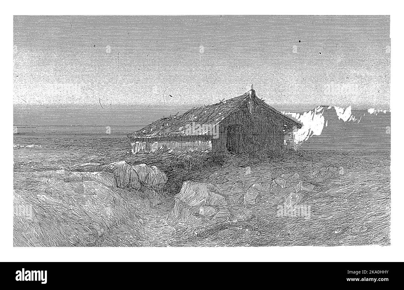 Auf einer Ebene mit Felsbrocken steht eine große Hütte. Berge sind im Hintergrund. Stockfoto