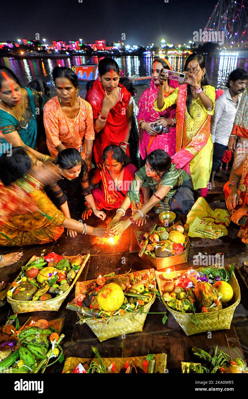 Kalkutta, Indien. 30. Oktober 2022. Hinduistische Anhänger werden gesehen, wie sie Abendrituale anlässlich der Chhath Puja am Ufer des Hooghly River durchführen. Chhath ist ein hinduistisches Fest, bei dem der Sonne Gebete gewidmet werden, um Dankbarkeit und Dankbarkeit für die Überwindung der Hürden des Lebens während des ganzen Jahres zu zeigen. Den ganzen Tag fasten Hindu-Anhänger suchen nach dem Segen der Lord Sun gemäß der hinduistischen Mythologie. Da das Festival der Sonne gewidmet ist, findet es jedes Jahr während der Sonnenaufgang und -Untergang Ende Oktober/Mitte November statt. Kredit: SOPA Images Limited/Alamy Live Nachrichten Stockfoto
