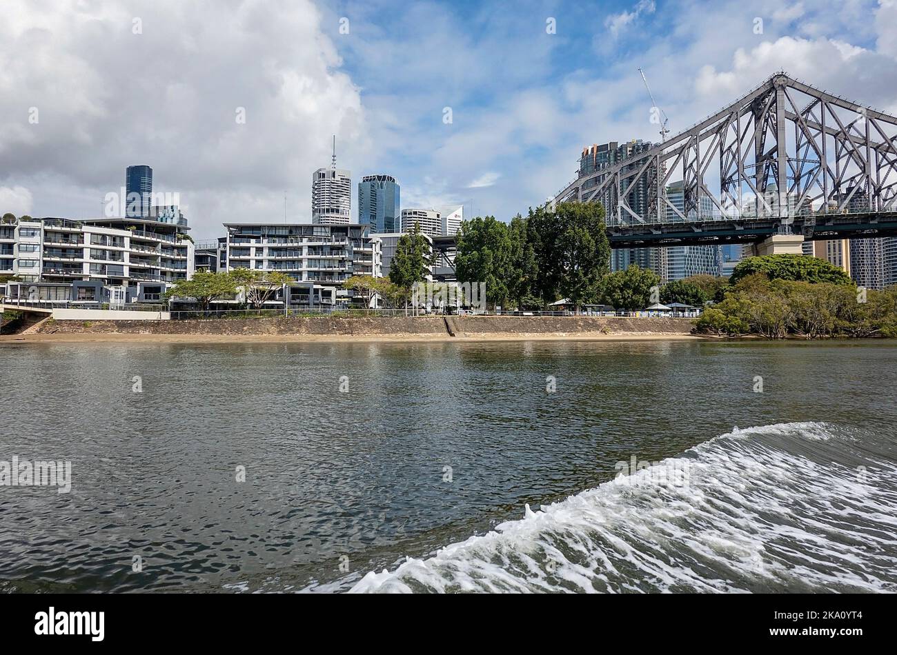 Brisbane, Queensland, Australien - 2022. August: Eine Stahlbrücke und Wohneinheiten am Ufer des Brisbane River. Stockfoto