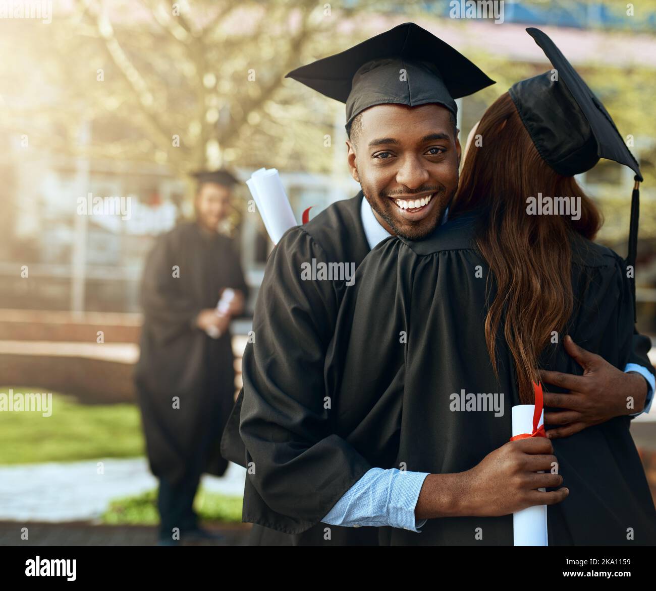 Paare, die zusammen studieren...Porträt eines glücklichen jungen Mannes und einer Frau, die sich am Abschlusstag umarmen. Stockfoto