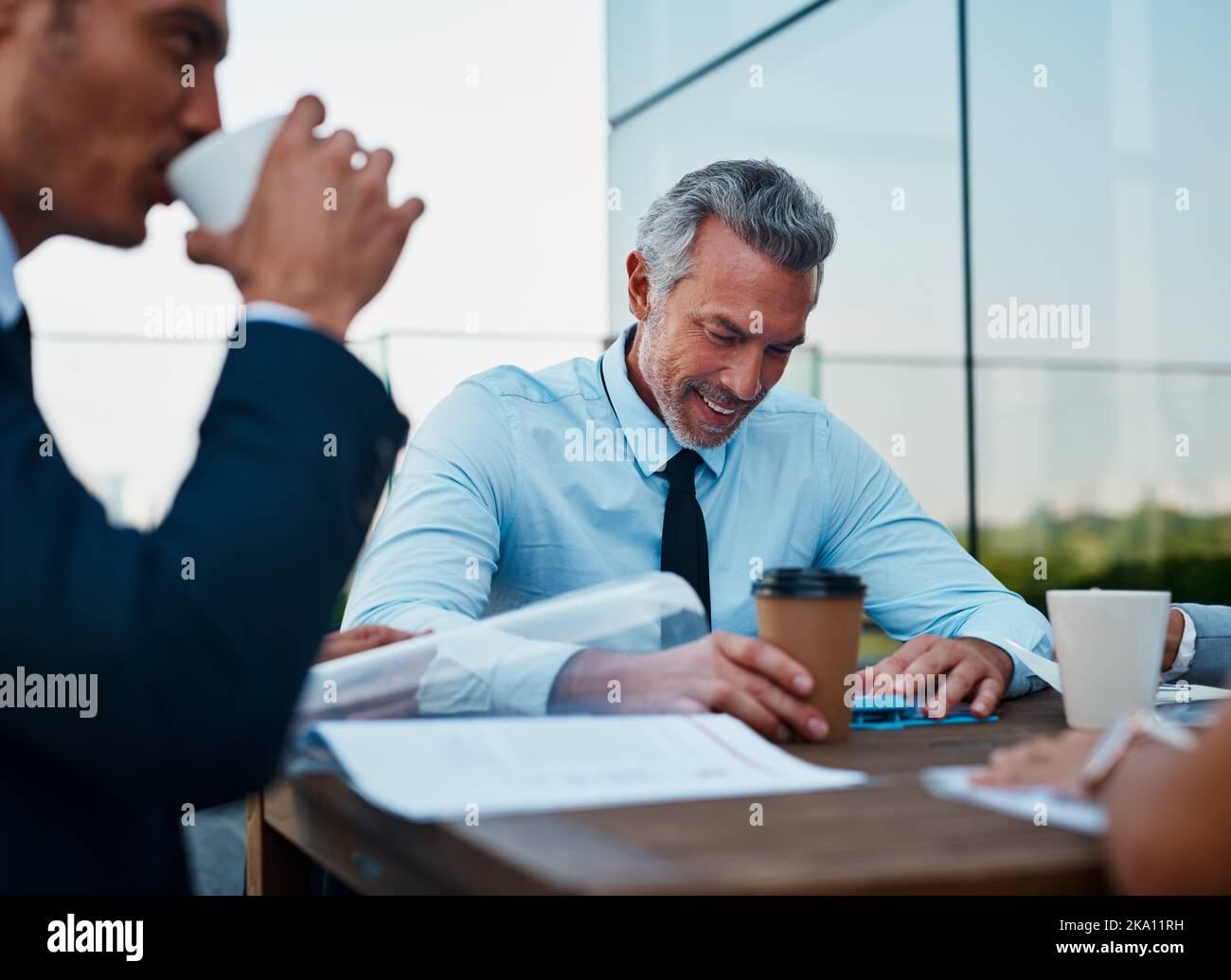 Es fühlt sich großartig an, wenn wir neue Ideen entwickeln. Geschäftsleute, die sich draußen treffen. Stockfoto