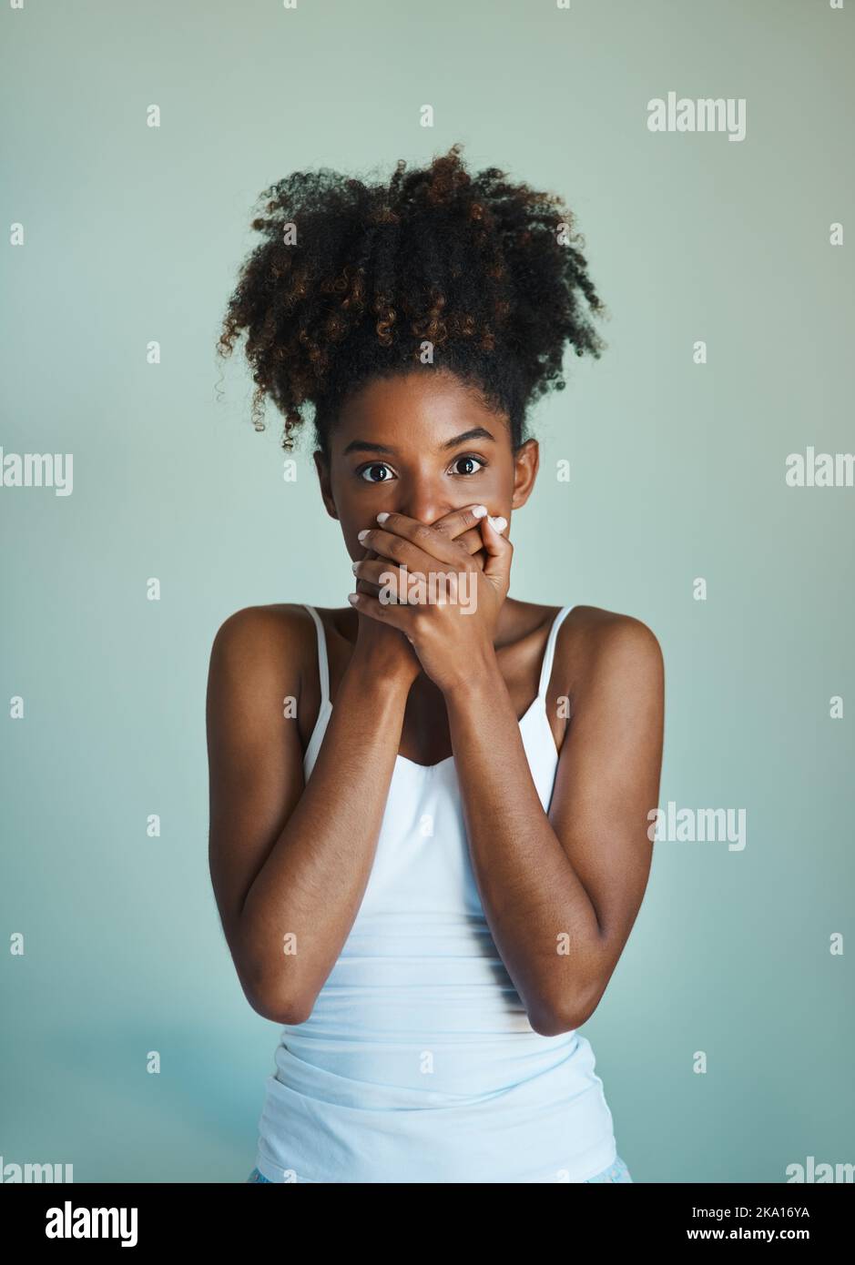 Wenn Sie nichts nettes zu sagen haben, Sei still. Studioaufnahme einer schönen, frisch gesichtigen jungen Frau, die vor grünem Hintergrund posiert. Stockfoto