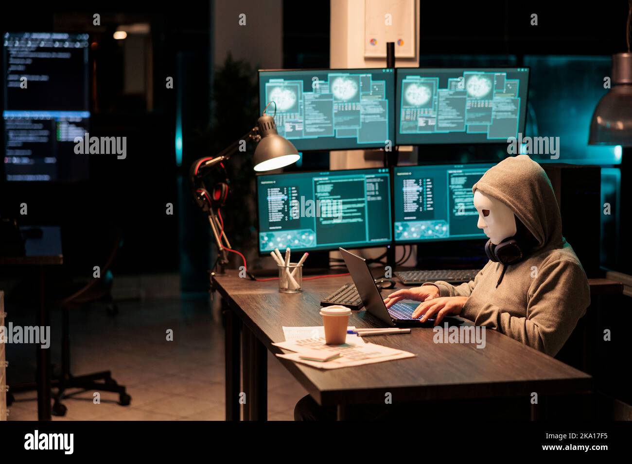 Betrüger mit Maske und Haube Hacking Sicherheitsserver, Installation von Viren, um Computer-Malware zu erstellen und stehlen große Online-Daten. Maskierter krimineller Hacker, der nachts das Netowrk-System zerbricht. Stockfoto