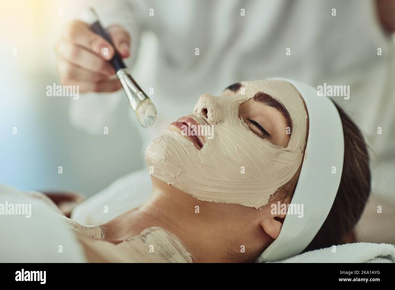 Geben Sie Ihrer Haut den Schub, den sie verdient. Eine attraktive junge Frau bekommt eine Gesichtsbehandlung in einem Beauty-Spa. Stockfoto