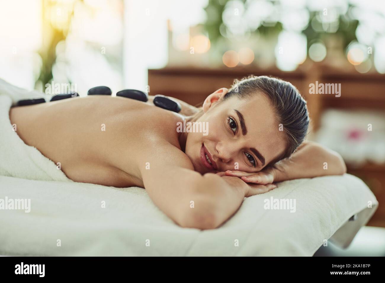 Nichts lässt mich entspannen wie eine Hot Stone Massage. Porträt einer attraktiven jungen Frau, die in einem Beauty Spa eine Hot Stone Massage bekommt. Stockfoto