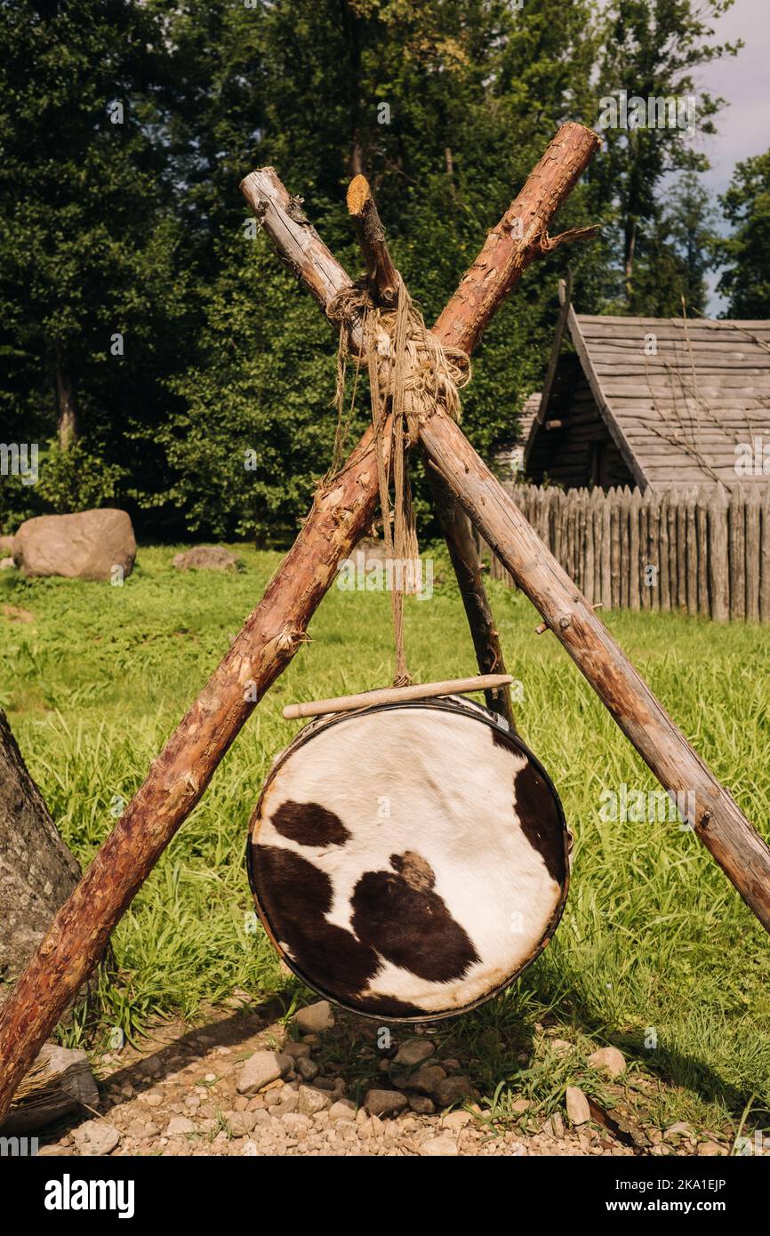 Eine alte traditionelle Trommel mit Fell, das in einem mittelalterlichen Dorf hängt Stockfoto