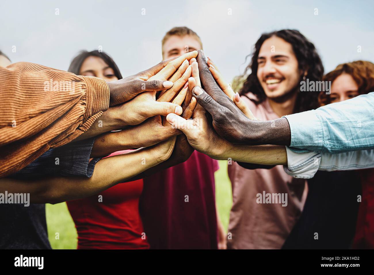 Gruppe von multiethnischen Gemeinschaft von glücklichen Menschen, die Spaß haben, die Hände in den Park zu verbinden - multiethnische vielfältige Gruppe von Studenten hoch fünf - Vertrauen Stockfoto
