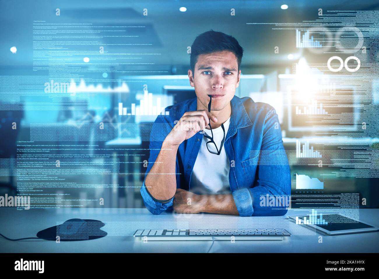 Er muss ständig neue Lösungen finden. Porträt eines fokussierten jungen Programmierers, der in der Nacht im Büro an seinem Computer arbeitet. Stockfoto