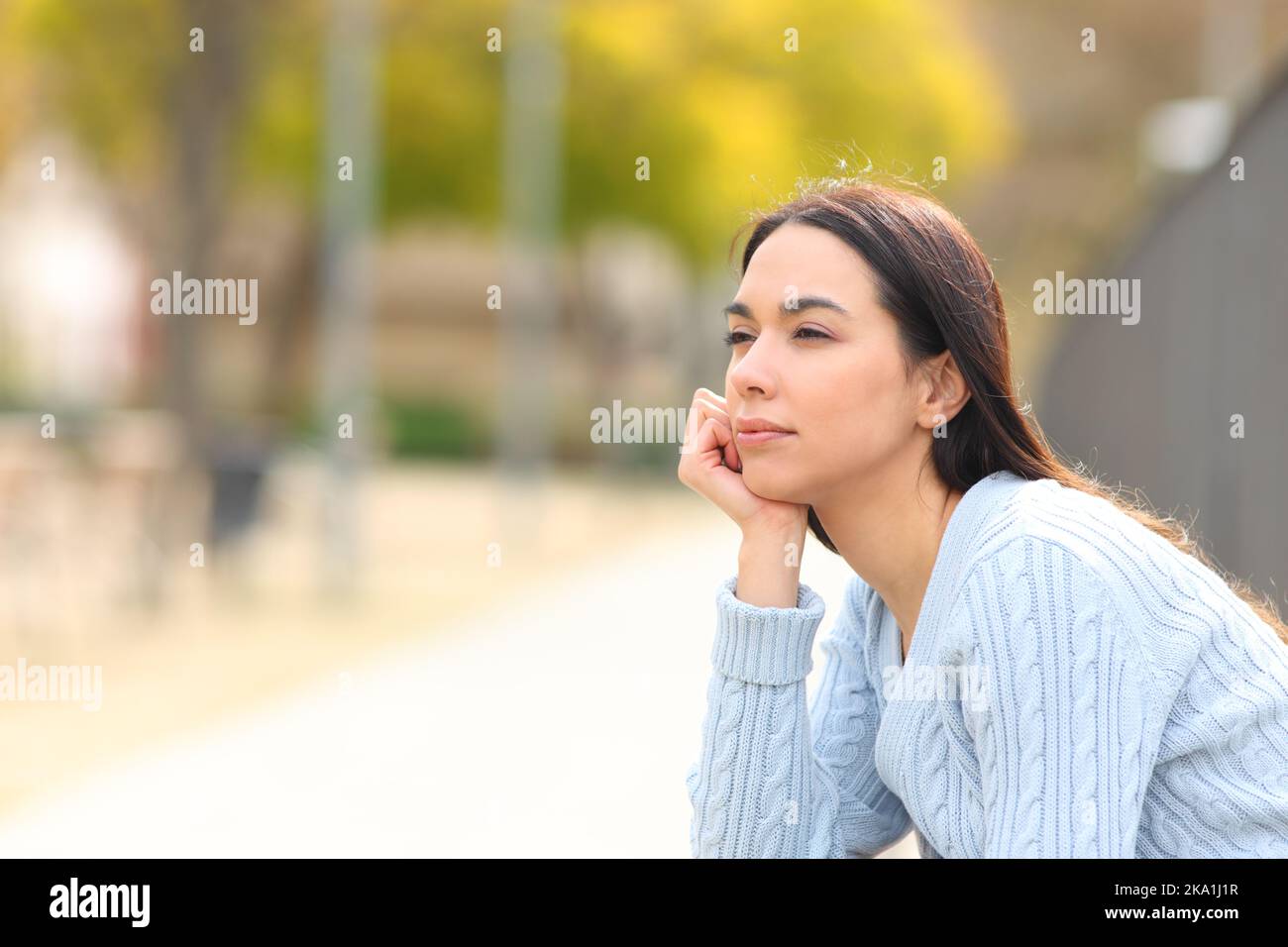 Entspannte Frau, die in einem Park die Aussicht betrachtet Stockfoto
