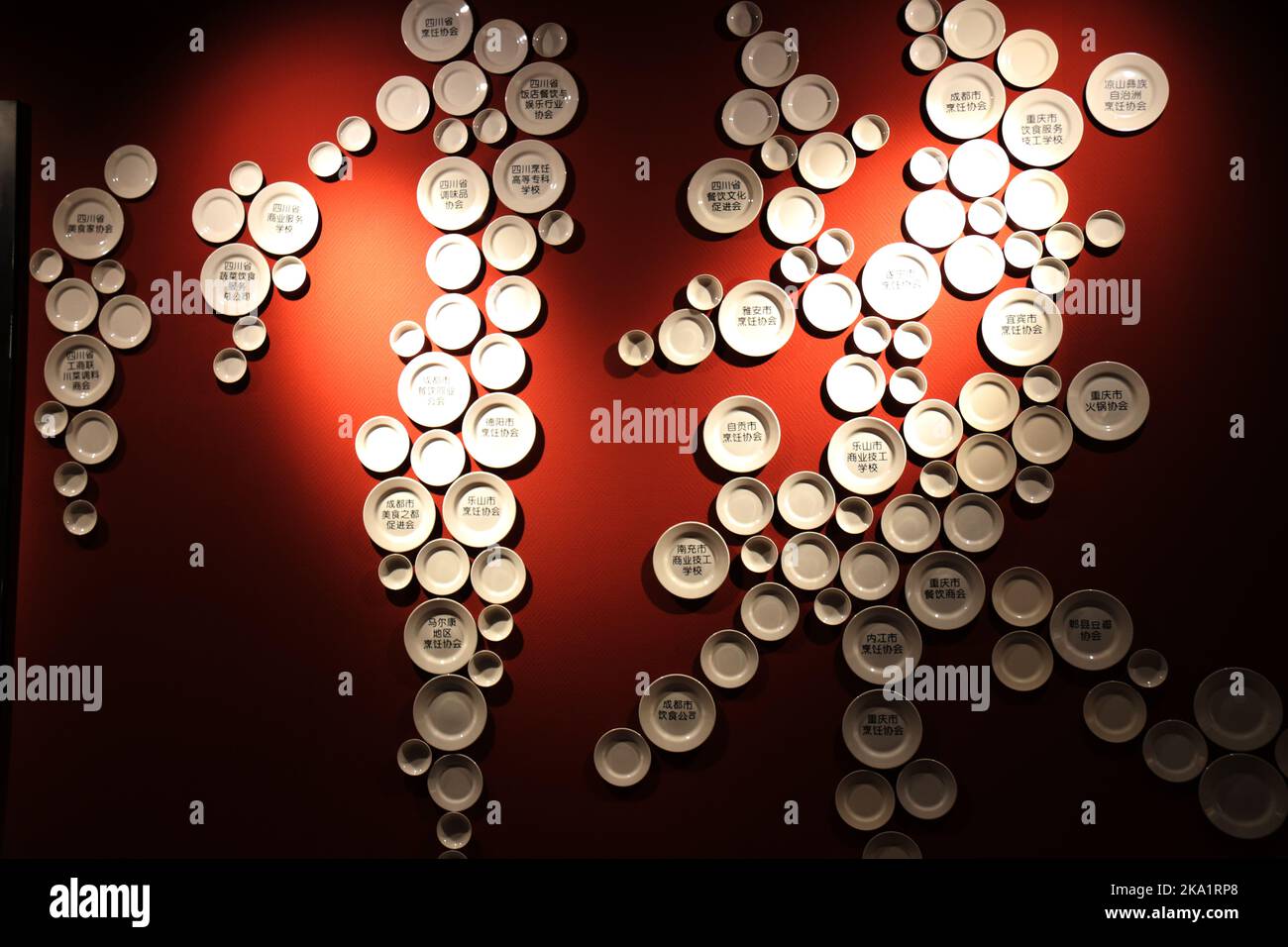 LIANYUNGANG, CHINA - 31. OKTOBER 2022 - der Besitzer hängt Besteck an die Wand, um die Figur "Sichuan Cuisine" in einem Sichuan Restaurant in Lianyun zu bilden Stockfoto